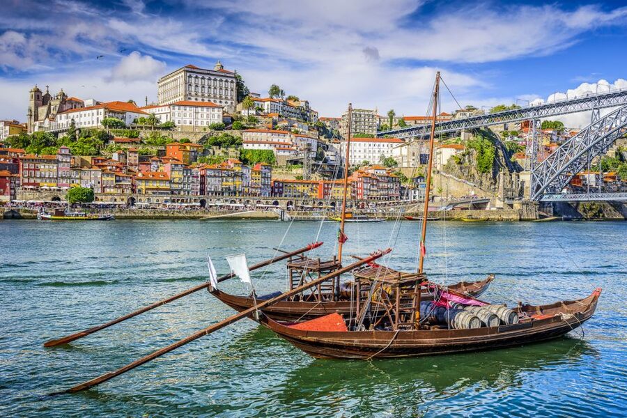 Rabelo boats moored below the painted houses of the Ribeira